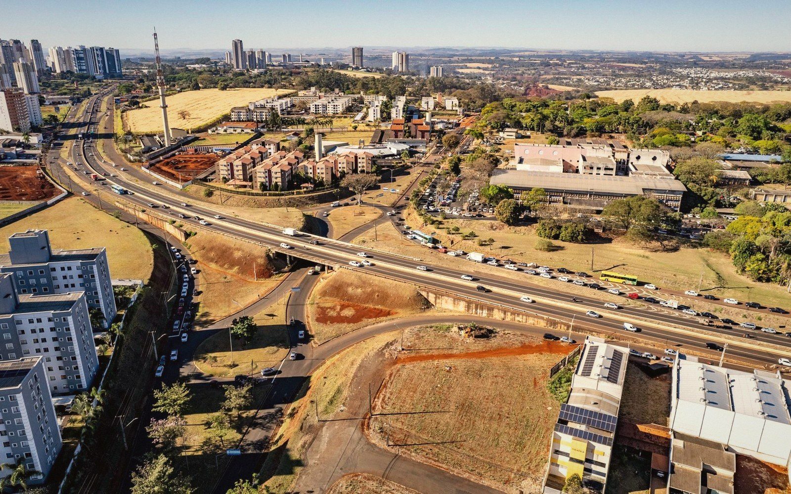 Aerial view of a highway overpass and traffic winding through a developing cityscape