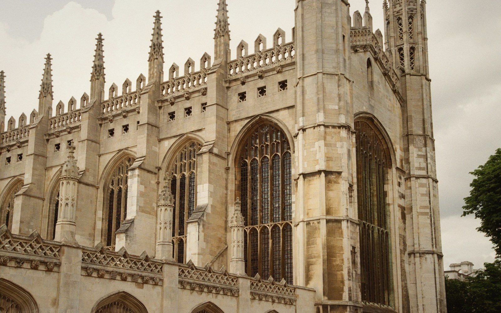 Gothic stone chapel exterior with tall arched windows and ornate spired pinnacles