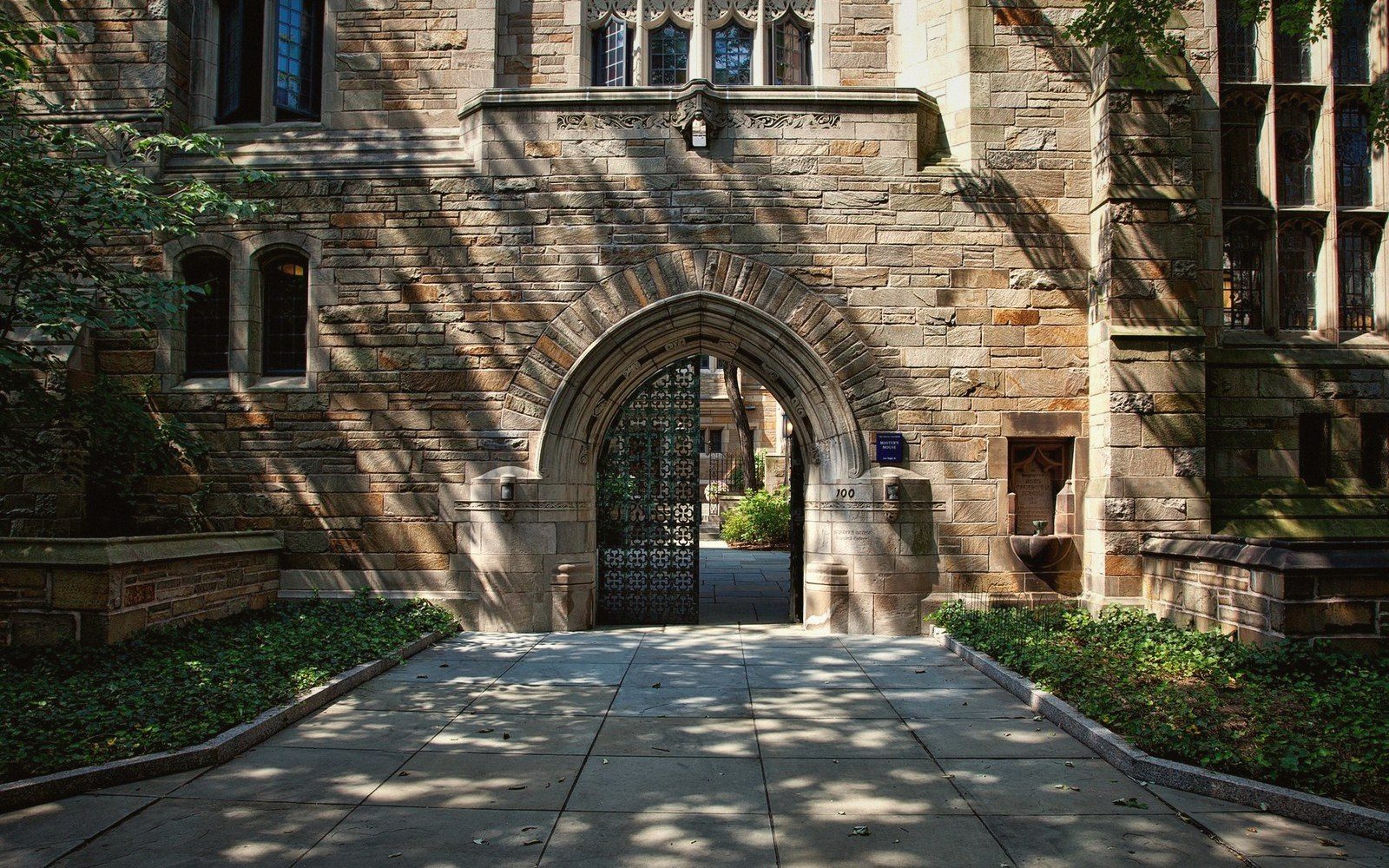 Street outside a university campus where stone buildings meet the city grid